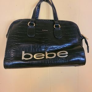 Bebe, Black Handbag. Handbag studs on bottom. Gold lettering.